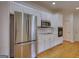 Kitchen showcasing stainless steel refrigerator, microwave, and ample white cabinetry at 1880 Hickory Station Cir, Snellville, GA 30078