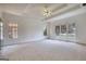 Spacious bedroom featuring neutral carpet, large windows offering views, and a decorative ceiling fan at 1880 Hickory Station Cir, Snellville, GA 30078