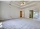 Spacious bedroom featuring neutral carpet, access to the bathroom and closet, with a decorative ceiling fan at 1880 Hickory Station Cir, Snellville, GA 30078