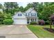 Inviting two-story home featuring a lush front lawn, charming landscaping, and a convenient two-car garage at 2022 Maple Ridge, Acworth, GA 30101