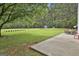 Expansive backyard with a large lawn and patio, featuring mature trees and a storage shed at 391 Massengale Rd, Brooks, GA 30205