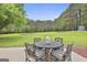 Spacious backyard featuring a patio with seating, lush green grass, and tall, mature trees at 391 Massengale Rd, Brooks, GA 30205