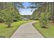 An estate home featuring a long winding driveway framed by mature trees and verdant landscaping at 391 Massengale Rd, Brooks, GA 30205