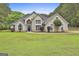 Stunning two-story home with a well-manicured lawn, decorative shrubbery, and a blue front door at 391 Massengale Rd, Brooks, GA 30205