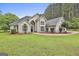 Stunning two-story home with a well-manicured lawn, decorative shrubbery, and a blue front door at 391 Massengale Rd, Brooks, GA 30205