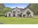 Stunning two-story home with a well-manicured lawn, decorative shrubbery, and a blue front door at 391 Massengale Rd, Brooks, GA 30205