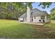 Beautiful backyard view of the home with a patio, lush green lawn, and mature trees at 391 Massengale Rd, Brooks, GA 30205