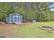 A blue storage shed with a ramp sits near a firepit at 391 Massengale Rd, Brooks, GA 30205