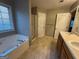 Bathroom featuring dual sinks, a large soaking tub, and a glass-enclosed shower at 851 Walkingstick Dr, Douglasville, GA 30134