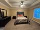 Spacious primary bedroom featuring carpet flooring, a ceiling fan, and a tray ceiling at 851 Walkingstick Dr, Douglasville, GA 30134