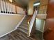 Inviting foyer with wood-look floors, staircase with wooden banister and neutral-toned walls at 851 Walkingstick Dr, Douglasville, GA 30134