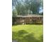 View of backyard with wooden deck, lawn, patio furniture, and brick on back of house at 288 Harper Se Rd, Atlanta, GA 30315