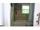 Bathroom with neutral tiled walls, window above the tub, and showerhead at 288 Harper Se Rd, Atlanta, GA 30315