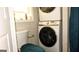 Bathroom with stacked washer and dryer unit and turquoise toilet seat cover at 288 Harper Se Rd, Atlanta, GA 30315