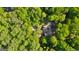 Aerial view showcases a private residence nestled among lush trees with a pool and manicured landscaping at 110 Woodland Rd, Fayetteville, GA 30214