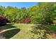 Spacious backyard with lush green lawn, vibrant Japanese Maple trees providing shade at 110 Woodland Rd, Fayetteville, GA 30214