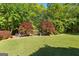Picturesque backyard featuring well-maintained lawn and vibrant Japanese Maple trees surrounding a sitting area at 110 Woodland Rd, Fayetteville, GA 30214