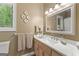 Bright bathroom with modern vanity, marble countertop, decorative wall plates, and window overlooking greenery at 110 Woodland Rd, Fayetteville, GA 30214