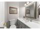 Half bathroom featuring a tiled floor, gray vanity, white sink and modern fixtures at 110 Woodland Rd, Fayetteville, GA 30214