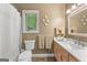 Bright bathroom with modern vanity, marble countertop, decorative wall plates, and window overlooking greenery at 110 Woodland Rd, Fayetteville, GA 30214