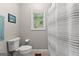 Well-lit bathroom featuring a shower curtain, tiled floors, and a compact design at 110 Woodland Rd, Fayetteville, GA 30214