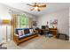 Neutral bedroom featuring futon, desk setup, and a view of the green outdoors at 110 Woodland Rd, Fayetteville, GA 30214