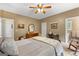 Comfortable bedroom featuring neutral colors, ceiling fan, wood furnishings, and adjoining bathroom at 110 Woodland Rd, Fayetteville, GA 30214