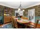 Dining room with hardwood floors, decorative wallpaper, and view into kitchen and living spaces at 110 Woodland Rd, Fayetteville, GA 30214