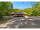 Charming brick home with a two-car garage, surrounded by mature trees and lush greenery at 110 Woodland Rd, Fayetteville, GA 30214