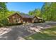 Gorgeous brick home featuring a private driveway and a lush, wooded landscape at 110 Woodland Rd, Fayetteville, GA 30214