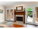 Classic wood-burning fireplace with decorative mantel, framed by doors to the outdoor spaces at 110 Woodland Rd, Fayetteville, GA 30214