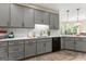 Bright kitchen featuring gray cabinets, modern countertops, and stainless steel sink at 110 Woodland Rd, Fayetteville, GA 30214