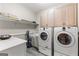 Well-equipped laundry room with shelving and side-by-side washer and dryer at 110 Woodland Rd, Fayetteville, GA 30214