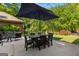 Outdoor patio featuring comfortable seating, a large umbrella for shade, and a tranquil backyard setting at 110 Woodland Rd, Fayetteville, GA 30214