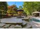 Backyard pool area with stone steps, adjacent lounge seating and a black fence at 110 Woodland Rd, Fayetteville, GA 30214