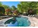 Backyard pool and spa with stone accents, surrounded by lush landscaping and relaxation seating areas at 110 Woodland Rd, Fayetteville, GA 30214