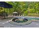 Outdoor pool area showcasing a luxurious jacuzzi and an umbrella-shaded table with chairs at 110 Woodland Rd, Fayetteville, GA 30214