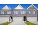 Up close view of townhomes with brick and gray siding, white trim, and attached garages at 240 Epping Dr, Stockbridge, GA 30281