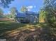 View of the backyard with a deck, trees, and a partial view of the home's rear elevation at 150 Park Timbers Drive, Sharpsburg, GA 30277