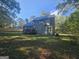 Backyard view of two-story home, highlighting the deck and partially wooded surroundings at 150 Park Timbers Drive, Sharpsburg, GA 30277