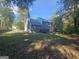 Wide backyard view of a two-story home with mature trees providing ample shade at 150 Park Timbers Drive, Sharpsburg, GA 30277