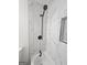 Close up on the new marbled tile and shower fixture within the newly remodeled bathroom at 150 Park Timbers Drive, Sharpsburg, GA 30277