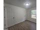 Bedroom with neutral walls, wood-look floors, a bright window, and multiple closet doors at 150 Park Timbers Drive, Sharpsburg, GA 30277