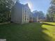 View of the home showcasing a manicured lawn with lush surrounding landscape and inviting natural light at 150 Park Timbers Drive, Sharpsburg, GA 30277