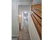 Hallway featuring wood-look floors and an open staircase, with glimpses of kitchen and bath at 150 Park Timbers Drive, Sharpsburg, GA 30277