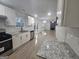Bright kitchen features white cabinets, stainless appliances, and granite countertops, adjacent to a spacious living area at 150 Park Timbers Drive, Sharpsburg, GA 30277