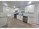 Updated kitchen boasts stainless steel appliances, white cabinets, granite countertops, and new flooring at 150 Park Timbers Drive, Sharpsburg, GA 30277