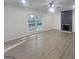 Well-lit living room showcases a modern fireplace, ceiling fan, and spacious layout with large windows at 150 Park Timbers Drive, Sharpsburg, GA 30277