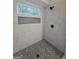 Elegant glass enclosed shower with a mosaic-tiled shower floor, shower niche, and a window bringing in natural light at 150 Park Timbers Drive, Sharpsburg, GA 30277
