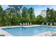 Community pool area with plenty of lounge chairs and a lush wooded backdrop for privacy at 256 Epping Dr, Stockbridge, GA 30281